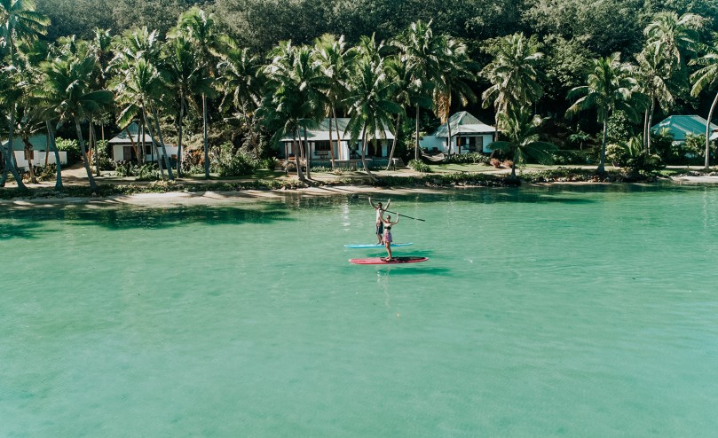 Couple standup paddle boarding in shallows at Tropica Island Resort Fiji Zero-Carbon Activities